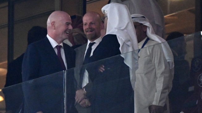 Presiden FIFA Gianni Infantino (kiri) berbicara dengan Presiden Konfederasi Sepak Bola Asia (AFC) Sheikh Salman bin Ibrahim al-Khalifa (kanan) selama pertandingan sepak bola Grup A Piala Asia AFC Qatar 2023 antara Qatar dan Lebanon di Stadion Lusail di Lusail, sebelah utara Doha pada 12 Januari 2024.HECTOR RETAMAL / AFP