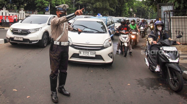 Polisi lalu lintas mengatur arus lalu lintas saat hari pertama Operasi Zebra Jaya 2024 di Jalan Iskandarsyah Raya, Kebayoran Baru, Jakarta, Senin (14/10/2024). [ANTARA FOTO/Reno Esnir/app/agr]
