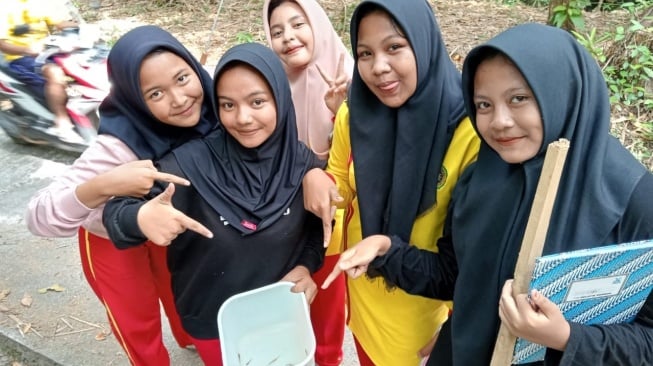 Para siswa dari MTS Darul Ulum Muhammadiyah Galur belajar mengenal ikan lokal di Surya Fish Farm Education milik Suryanto di Kulon Progo. [Dok. Pribadi]