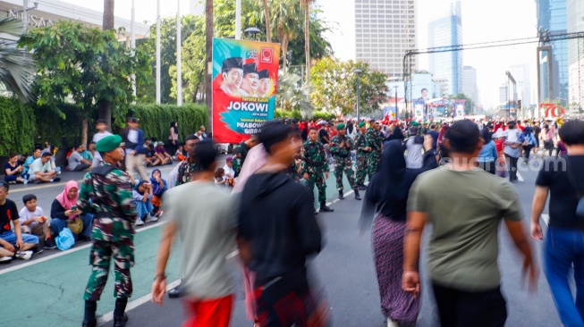 Suasana warga memadati Pesta Rakyat Pelantikan Prabowo-Gibran di kawasan Bundaran Hotel Indonesia (HI) di Jakarta, Minggu (20/10/2024). [Suara.com/Alfian Winanto]