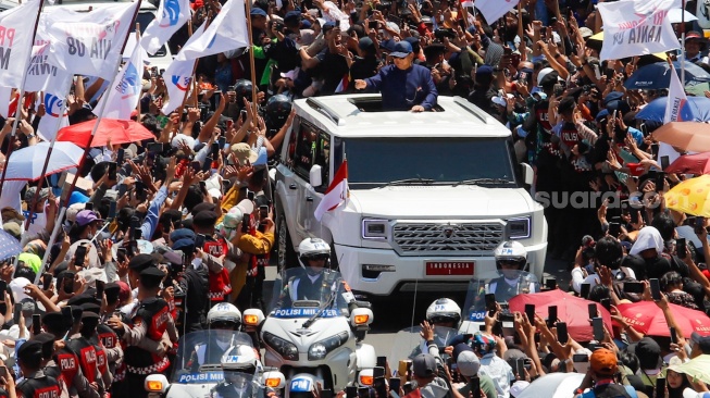 Presiden Prabowo Subianto melintas dan menyapa warga di Bundaran HI, Jakarta, pada Minggu (20/10/2024). [Suara.com/Alfian Winanto]