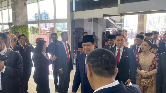 Susilo Bambang Yudhoyono dan Edi Baskoro Yudhoyono tiba di Gedung MPR sebelum pelantikan Prabowo Subianto menjadi presiden. [Suara.com/Bagaskara]