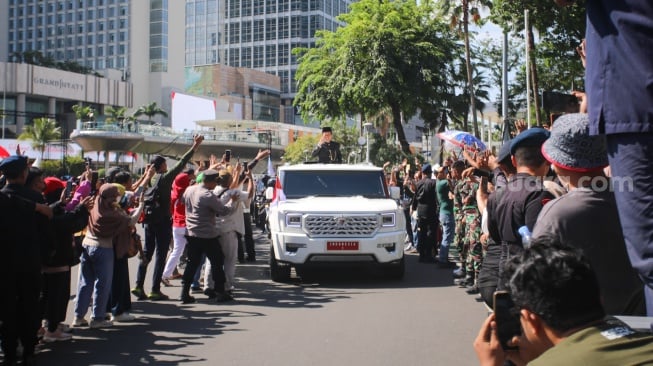 Presiden ketujuh RI Joko Widodo menyapa warga usai upacara pisah sambut di Istana Merdeka, Jakarta, Minggu (20/10/2024). [Suara.com/Alfian Winanto]