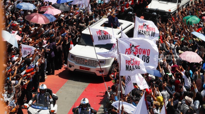 Presiden Prabowo Subianto melintas dan menyapa warga di Bundaran HI, Jakarta, pada Minggu (20/10/2024). [Suara.com/Alfian Winanto]