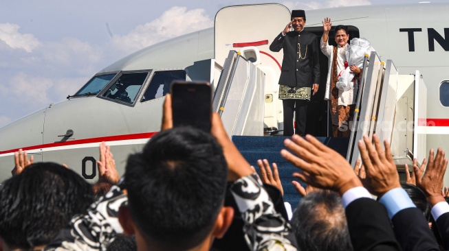 Presiden ketujuh RI Joko Widodo bersama Istri Iriana Joko Widodo memberi hormat dan salam saat akan memasuki pesawat Boeing 737 milik Angkatan Udara untuk bertolak ke Solo di Base Ops Lanud Halim Perdanakusuma, Jakarta, Minggu (20/10/2024). [ANTARA FOTO/Muhammad Adimaja/Spt]