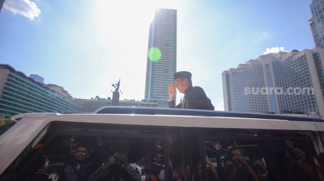 Presiden ketujuh RI Joko Widodo menyapa warga usai upacara pisah sambut di Istana Merdeka, Jakarta, Minggu (20/10/2024). [Suara.com/Alfian Winanto]