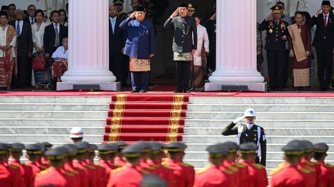 Presiden Prabowo Subianto (kiri) bersama Presiden ketujuh RI Joko Widodo (kanan) memberikan penghormatan kepada pasukan dalam upacara pisah sambut di Istana Merdeka, Jakarta, Minggu (20/10/2024). [ANTARA FOTO/Hafidz Mubarak A/app/Spt]