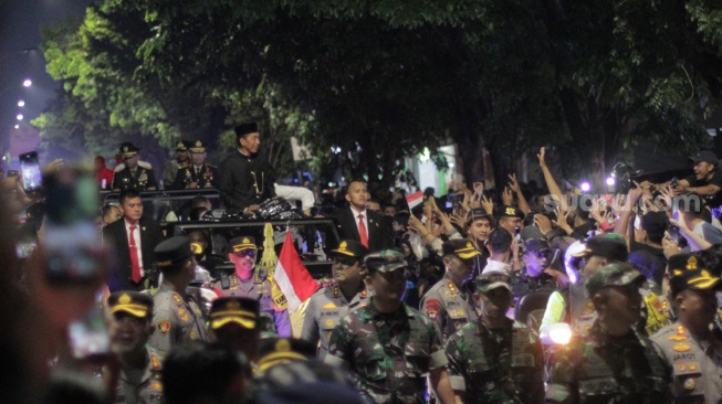 Mantan Presiden Jokowi menyapa ratusan ribu warga di ruas Jalan Adi Sucipto, Solo menuju kediaman pribadi kawasan Sumber, Banjarsari, Minggu (20/10/2024). [Suara.com/Ronald Seger Prabowo]