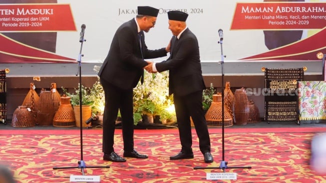 Menteri UMKM Maman Abdurrahman (kiri) bersalaman dengan Menteri UMKM periode 2019-2024 Teten Masduki (kanan) saat Sertijab dan Pisah Sambut di gedung Smesco Indonesia, Jakarta, Senin (21/10/2024). [Suara.com/Alfian Winanto]