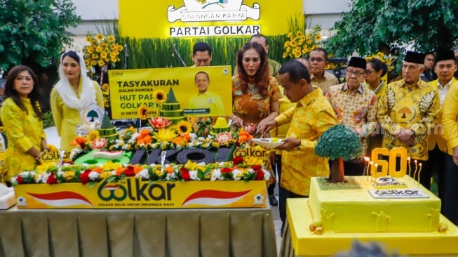 Ketua Umum Partai Golkar Bahlil Lahadalia (tengah) melakukan prosesi potong tumpeng saat perayaan HUT ke-60 Partai Golkar di Kantor DPP Golkar, Jakarta, Senin (21/10/2024). [Suara.com/Alfian Winanto]