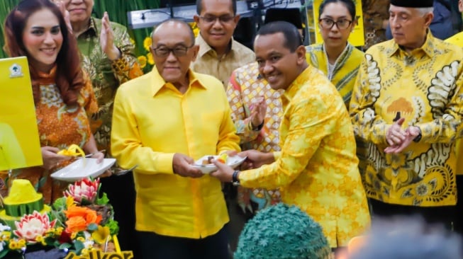 Ketua Umum Partai Golkar Bahlil Lahadalia (kanan) memberikan potongan tumpeng kepada Aburizal Bakri saat perayaan HUT ke-60 Partai Golkar di Kantor DPP Golkar, Jakarta, Senin (21/10/2024). [Suara.com/Alfian Winanto]