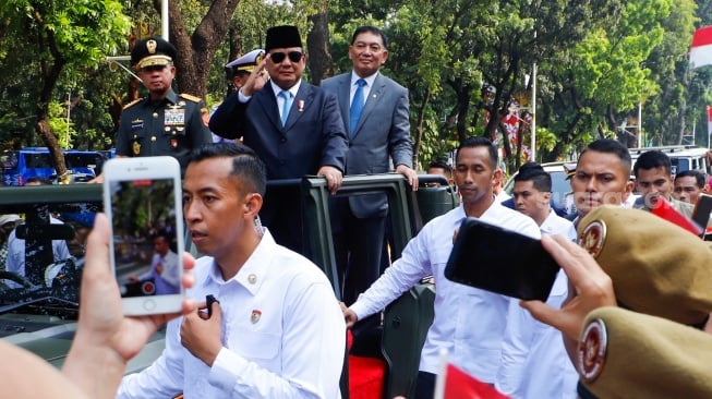 Presiden Prabowo Subianto (kedua kanan) bersama Menteri Pertahanan Sjafrie Sjamsoeddin (kanan) didampingi Panglima TNI Jenderal TNI Agus Subiyanto (kiri) dan KSAL Laksamana Muhammad Ali (kedua kiri) menaiki mobil rantis Maung menyapa pegawai Kemenhan usai upacara serah terima jabatan (sertijab) Menhan di kantor Kementerian Pertahanan, Jakarta, Selasa (22/10/2024). [Suara.com/Alfian Winanto]