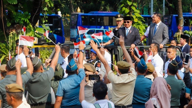 Presiden Prabowo Subianto (kedua kanan) bersama Menteri Pertahanan Sjafrie Sjamsoeddin (kanan) didampingi Panglima TNI Jenderal TNI Agus Subiyanto (kiri) dan KSAL Laksamana Muhammad Ali (kedua kiri) menaiki mobil rantis Maung menyapa pegawai Kemenhan usai upacara serah terima jabatan (sertijab) Menhan di kantor Kementerian Pertahanan, Jakarta, Selasa (22/10/2024). [Suara.com/Alfian Winanto]