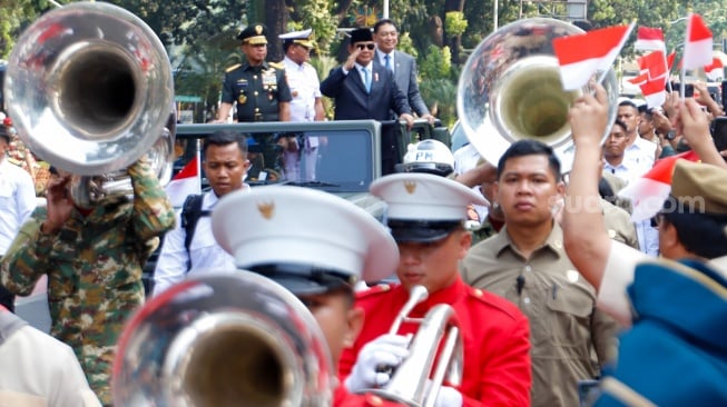 Presiden Prabowo Subianto (kedua kanan) bersama Menteri Pertahanan Sjafrie Sjamsoeddin (kanan) didampingi Panglima TNI Jenderal TNI Agus Subiyanto (kiri) dan KSAL Laksamana Muhammad Ali (kedua kiri) menaiki mobil rantis Maung menyapa pegawai Kemenhan usai upacara serah terima jabatan (sertijab) Menhan di kantor Kementerian Pertahanan, Jakarta, Selasa (22/10/2024). [Suara.com/Alfian Winanto]