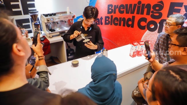 Pengunjung mengikuti pelatihan membuat Latte Art di acara Jakarta International Coffee Conference di Gedung AA Maramis di Jakarta, Rabu (23/10/2024). [Suara.com/Alfian Winanto]