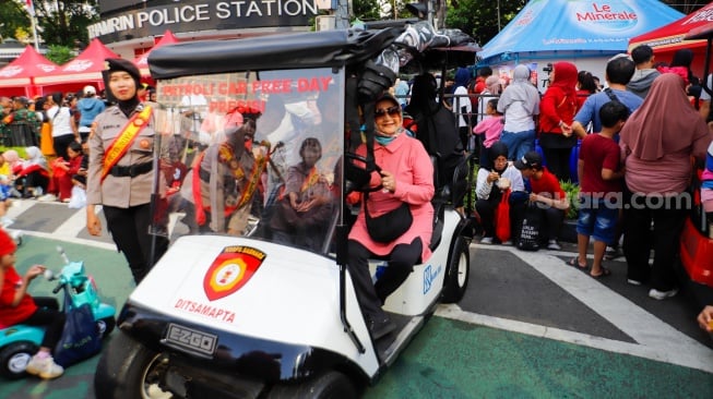 Warga berswafoto saat Car Free Day (CFD) di Bundaran HI, Jakarta, Minggu (27/10/2024). [Suara.com/Alfian Winanto]