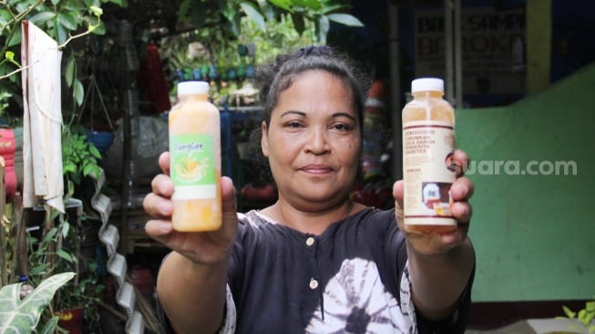 Pembuat minuman herbal Yuliana di Kampung Setaman, Rawageni, Kelurahan Ratu Jaya, Kecamatan Cipayung, Depok, Jawa Barat, Sabtu (26/10/2024). [Suara.com/Dwi Bowo Raharjo]