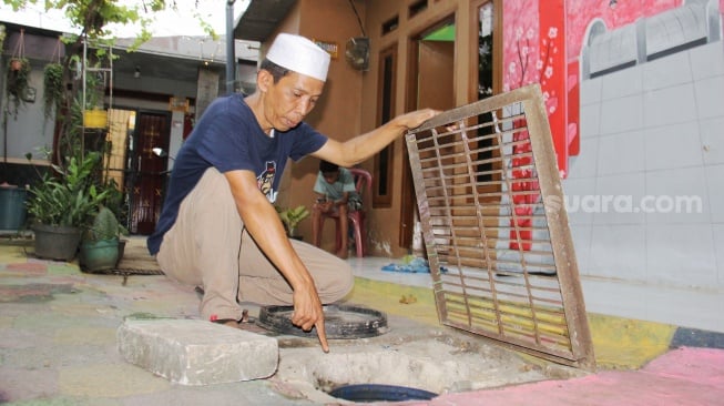 Ketua RW 7 Sanusi menunjukkan biopori lele di Kampung Setaman, Rawageni, Kelurahan Ratu Jaya, Kecamatan Cipayung, Depok, Jawa Barat, Sabtu (26/10/2024). [Suara.com/Dwi Bowo Raharjo]