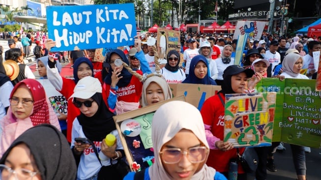 Aktivis lingkungan dari komunitas Aksi Muda Jaga Iklim saat pawai yang bertajuk Plastik Gak Asik di kawasan Bundaran HI, Jakarta, Minggu (27/10/2024). [Suara.com/Alfian Winanto]