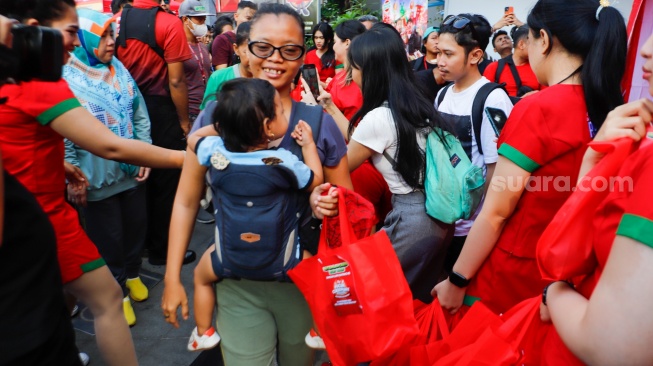 Warga antri untuk mendapatka  makanan gratis dalam acara Pucuk Coolinary Festiv saat Car Free Day di Bundaran HI, Jakarta, Minggu (27/10/2024). [Suara.com/Alfian Winanto]