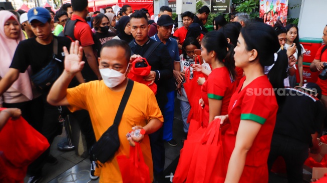 Warga antri untuk mendapatkan makanan gratis dalam acara Pucuk Coolinary Festiv saat Car Free Day di Bundaran HI, Jakarta, Minggu (27/10/2024). [Suara.com/Alfian Winanto]