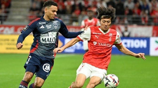 Bek Brest Kenny Lala (kiri) berebut bola dengan pemain depan Reims asal Jepang, Keito Nakamura (kanan) selama pertandingan Liga Prancis antara Stade de Reims vs Brest di Stade Auguste-Delaune di Reims, Prancis utara pada tanggal 26 Oktober 2024.FRANCOIS NASCIMBENI / AFP.