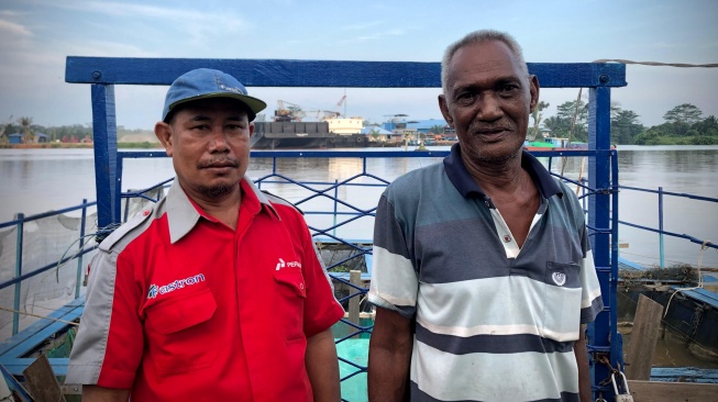 Dari kiri ke kanan, Boy dan Juanda, pengelola keramba ikan nila KBA di Gang Durian, Sungai Raya, Kubu Raya (Suara.com/Maria)