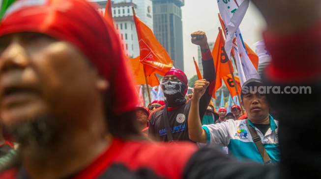 Para buruh dari berbagai elemen organisasi saat melakukan aksi unjuk rasa di kawasan Patung Kuda, Jakarta Pusat, Kamis (31/10/2024). [Suara.com/Alfian Winanto]
