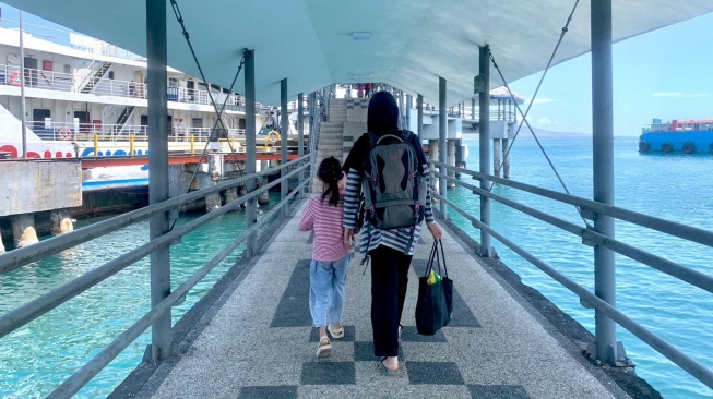 Penumpang Tengah memasuki kapal milik PT ASDP Indonesia Ferry (Persero).