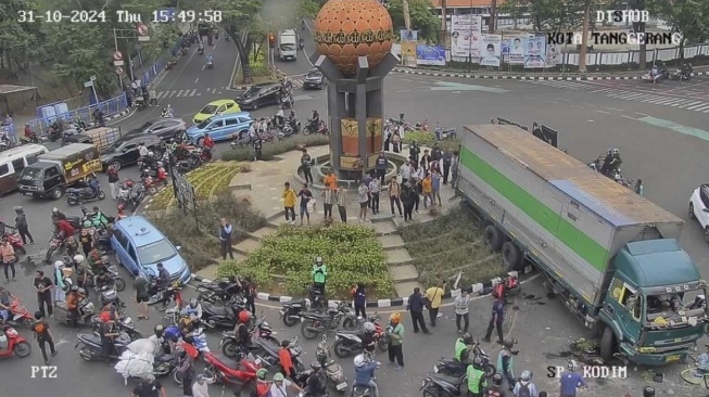 Truk kontainer yang disopiri ugal-ugalan hingga mengakibatkan tabrakan beruntun di jalan raya kawasan Kota Tangerang akhirny berhenti di Tugu Adipura. [CCTV Kodim]