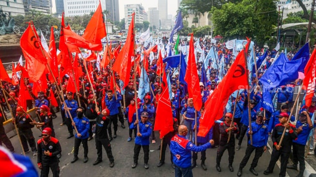 Para buruh dari berbagai elemen organisasi saat melakukan aksi unjuk rasa di kawasan Patung Kuda, Jakarta Pusat, Kamis (31/10/2024). [Suara.com/Alfian Winanto]
