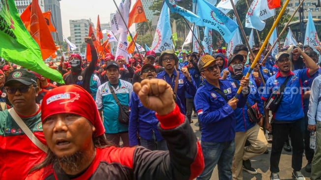 Para buruh dari berbagai elemen organisasi saat melakukan aksi unjuk rasa di kawasan Patung Kuda, Jakarta Pusat, Kamis (31/10/2024). [Suara.com/Alfian Winanto]
