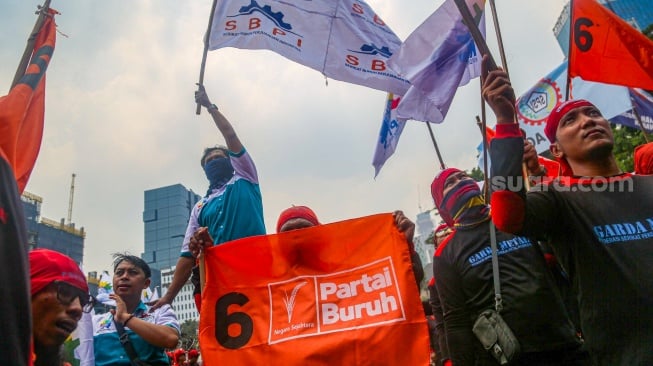 Para buruh dari berbagai elemen organisasi saat melakukan aksi unjuk rasa di kawasan Patung Kuda, Jakarta Pusat, Kamis (31/10/2024). [Suara.com/Alfian Winanto]
