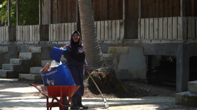 Seorang warga sedang bersih-bersih di Kampung Wisata Bakau Serip, Nongsa [suara.com/eliza gusmeri]