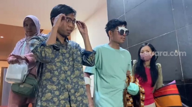 Agus Salim korban penyiraman air keras didampingi kuasa hukum dan keluarga usai diperika di Mapolda Metro Jaya, Jakarta, Jumat (1/11/2024) [Suara.com/Adiyoga Priyambodo]