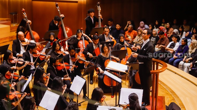 Konduktor Addie MS bersama Grup musik Light Ministry Orchestra (LMO) membawakan lagu saat konser kedua bertajuk 'A MILLION Light' di Aula Simfonia, Jakarta (3/11/2024). [Suara.com/Alfian Winanto]