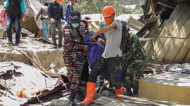 Anggota tim penyelamat membawa kantong jenazah berisi korban letusan Gunung Lewotobi Laki-Laki di Desa Klatanlo, Kabupaten Flores Timur, Nusa Tenggara Timur, Senin (4/11/2024). [ARNOLD WELIANTO / AFP]