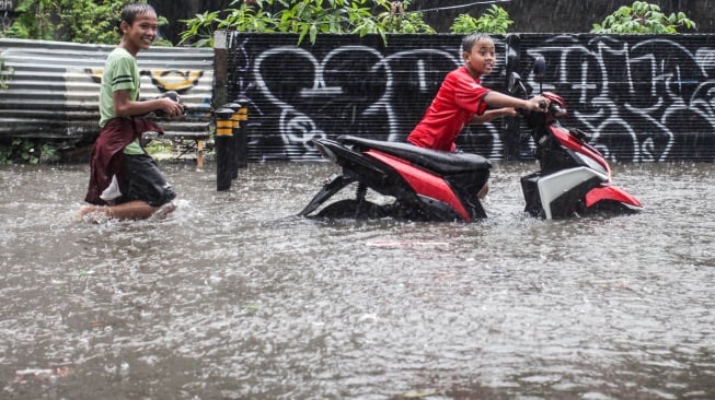 Dua anak mendorong motor saat banjir merendam Jalan Cipete Utara, Jakarta, Selasa (5/11/2024).i  [ANTARA FOTO/Zaky Fahreziansyah/RIV/rwa]