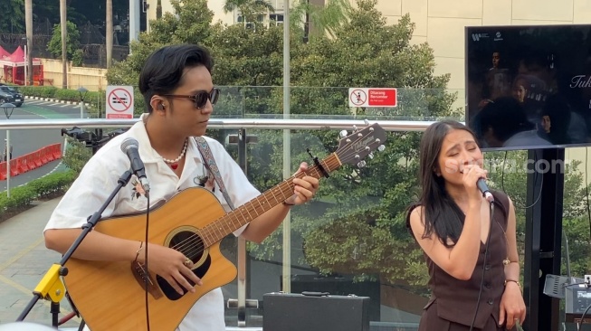 Prilly Latuconsina dan personel Daun Jatuh dalam perilisan single Tuk Singgah di Halte TransJakarta Tosari, Jumat (8/11/2024). [Suara.com/Adiyoga Priyambodo]