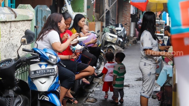 Warga beraktivitas di permukiman padat penduduk RW 12 Tanah Tinggi, Johar Baru, Jakarta, Selasa (12/11/2024). [Suara.com/Alfian Winanto]
