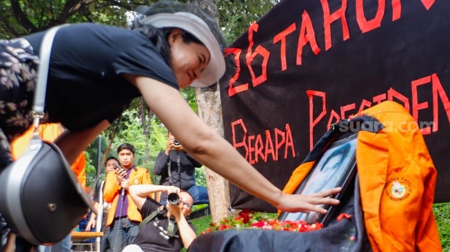 Anggota Komisi untuk Orang Hilang dan Korban Tindak Kekerasan (KontraS) dan Senat Fakultas Hukum Unika Atma Jaya melakukan aksi tabur bunga saat peringatan 26 Tahun Tragedi Semanggi di Universitas Atma Jaya, Jakarta, Rabu (13/11/2024). [Suara.com/Alfian Winanto]