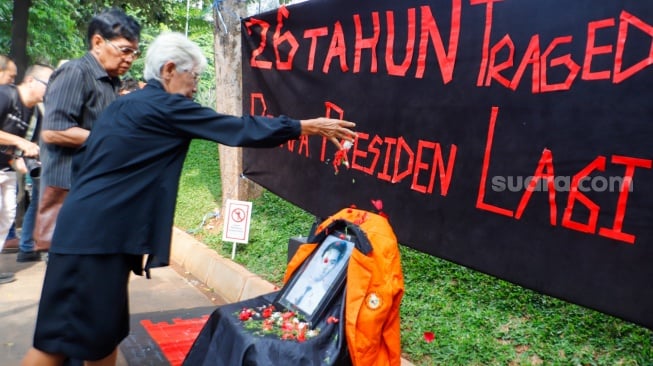 Maria Katarina Sumarsih melakukan aksi tabur bunga saat peringatan 26 Tragedi Semanggi di Universitas Atma Jaya, Jakarta, Rabu (13/11/2024).  [Suara.com/Alfian Winanto]
