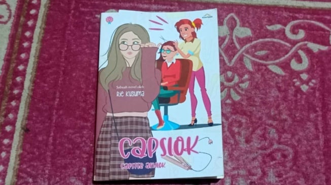 Duka di Balik Komedi, Ulasan Novel Capslok: Capster Anjlok