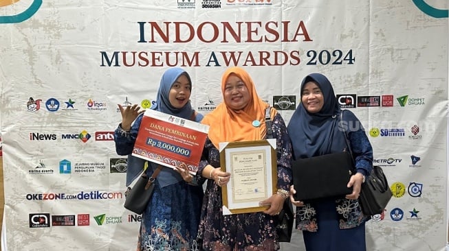 Kepala UPTD Museum Mulawarman, Isnawati (tengah) memegang Piagam Penghargaan Museum Lestari. [Ist]