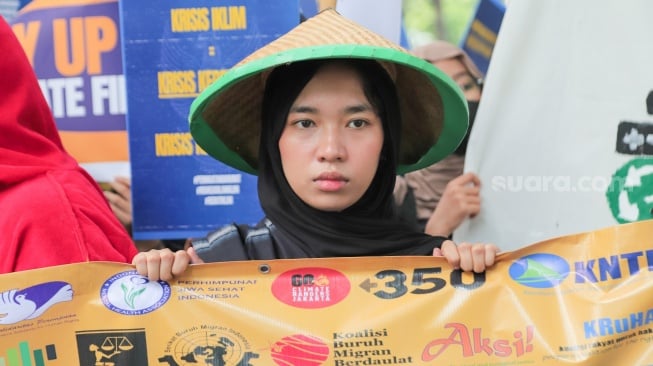 Sejumlah aktivis dari Aliansi Rakyat untuk Keadilan Iklim (ARUKI) melakukan aksi unjuk rasa di depan Kementerian Lingkungan Hidup, Jakarta, Senin (18/11/2024). [Suara.com/Alfian Winanto]