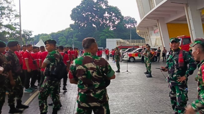 Petugas keamanan gabungan TNI dan Polri menggelar koordinasi sebagai persiapan untuk mengamankan kawasan ring road 1 Stadion Utama Gelora Bung Karno (SUGBK) Jakarta, Selasa (19/11/2024). [Suara.com/Arief Apriadi]