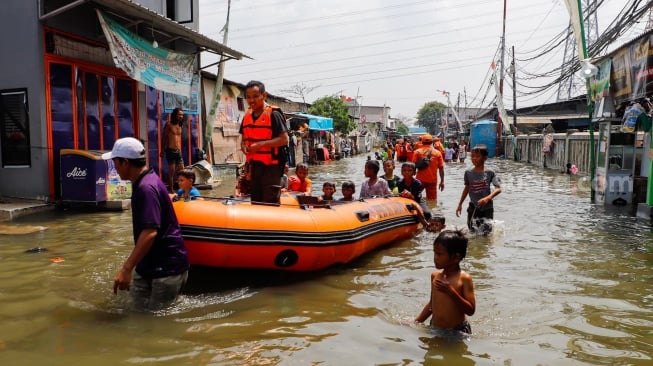 Warga beraktivitas di tengah banjir rob yang menggenangi wilayah Muara Angke, Jakarta Utara, Selasa (19/11/2024). [Suara.com/Alfian Winanto]