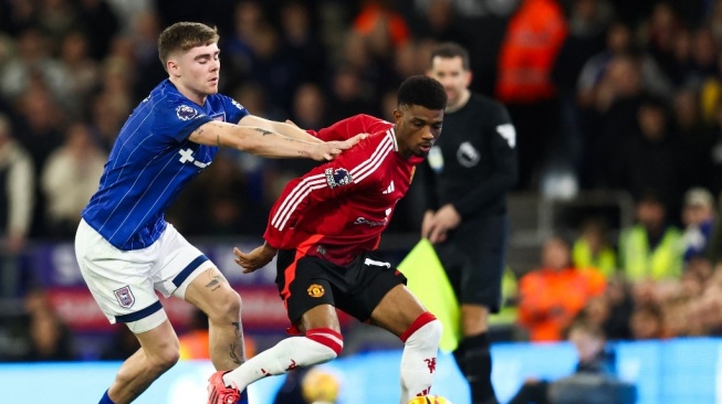 Bek Ipswich Town, Leif Davis (kiri) berebut bola dengan gelandang Manchester United asal Pantai Gading, Amad Diallo selama pertandingan Liga Inggris 2024/2025 antara Ipswich Town vs Manchester United di Portman Road di Ipswich, Inggris timur pada 24 November 2024.Darren Staples / AFP