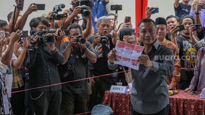 Calon Gubernur DKI Jakarta nomor urut 2 Dharma Pongrekun (kanan) menunjukkan kertas suara sebelum menggunakan hak pilihnya dalam Pemilihan Kepala Daerah (Pilkada) serentak di TPS 31 Lebak Bulus, Jakarta Selatan, Rabu (27/11/2024). [ANTARA FOTO/Fauzan/aww]