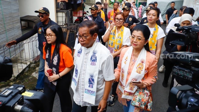 Calon gubernur DKI Jakarta nomor urut 3 Pramono Anung ditemani Istri dan putrinya berjalan menuju Tempat Pemungutan Suara (TPS) di Cipete Selatan, Jakarta, Rabu (27/11/2024). [Suara.com/Alfian Winanto]